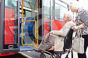 Senior Couple Boarding Bus Using Wheelchair Access Ramp