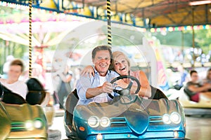 Senior couple in the bumper car at the fun fair