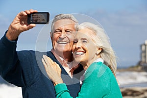 Senior Couple With Camera On Beach