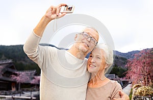 Senior couple with camera over asian village