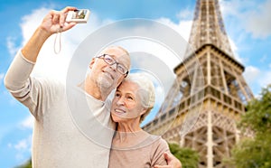 Senior couple with camera over eiffel tower