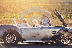 Senior couple, car and problem by road with sunshine for vacation, roadtrip and assistance. Mature people, engine check