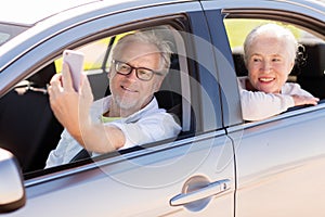 Senior couple in car taking smartphone selfie