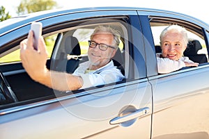 Senior couple in car taking smartphone selfie