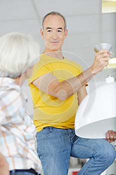 senior couple changing to more efficient light bulb