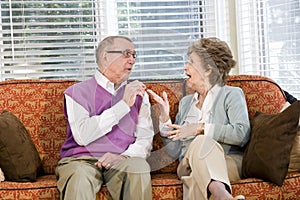 Senior couple chatting on living room couch