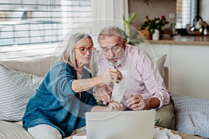 Senior couple checking their bills, concept of family finance.