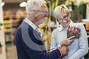 Senior couple are choosing flowers at garden center