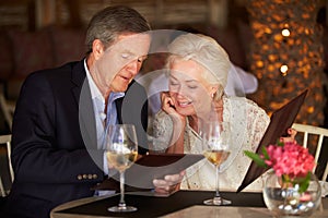 Senior Couple Choosing From Menu In Restaurant