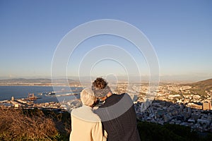 Senior, couple and city skyline outdoor, happy elderly people on hill for scenic view of buildings and sky. Bonding