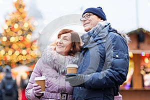 Senior couple with coffee at christmas market