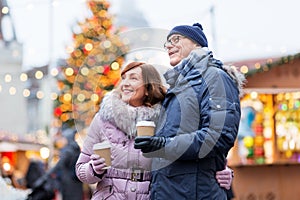 Senior couple with coffee at christmas market