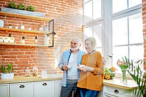 Senior couple with coffee on the kitchen at home