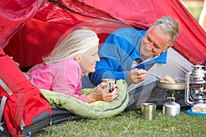 Senior Couple Cooking Breakfast On Camping Holiday