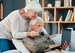 Senior couple, credit card and laptop on home sofa for ecommerce, online shopping and paying bills with fintech banking
