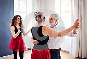 Senior couple in dancing class with dance teacher.