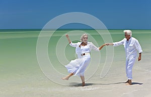 Senior Couple Dancing Holding Hands on A Beach