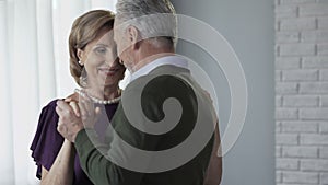 Senior couple dancing, man whispering to woman ear, romantic relationship, date