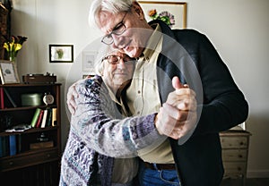 Senior couple dancing together at home