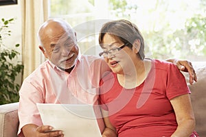 Senior Couple Discussing Document At Home