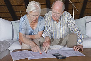 Senior couple discussing over medical bills in living room