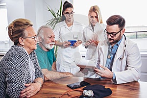 Senior Couple In Discussion With Health Visitor At Home.