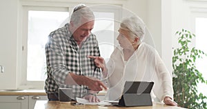 Senior couple, documents and planning on tablet with financial paperwork, taxes or mortgage loan at home. Questions