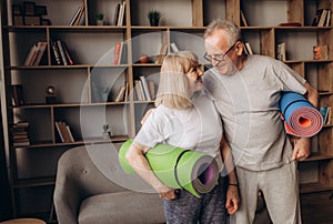 Senior couple is doing fitness training at home.Standing with fitness yoga carpets. Healthy lifestyle concept.