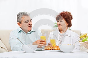 Senior couple drink orange juice breakfast