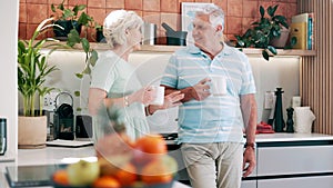 Senior couple, drinking coffee and communication in kitchen, bonding and relaxing together. Elderly people, tea and