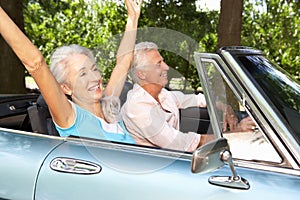 Senior couple driving sports car