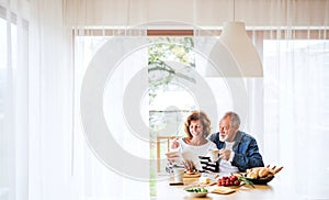 Senior couple eating breakfast at home.