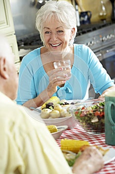 Senior Couple Eating Meal Together In Kitchen