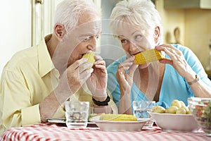 Senior Couple Eating Meal Together In Kitchen