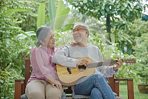 senior couple elderly man playing the guitar while his wife is singing together