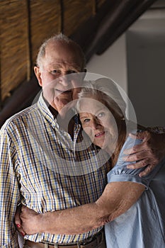 Senior couple embracing each other at home