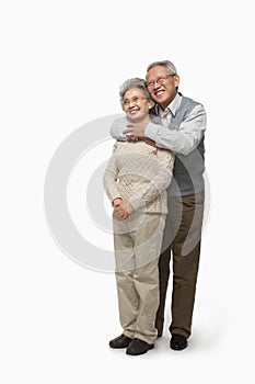 Senior couple embracing, studio shot