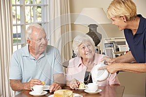 Senior Couple Enjoying Afternoon Tea Together At Home With Home Help