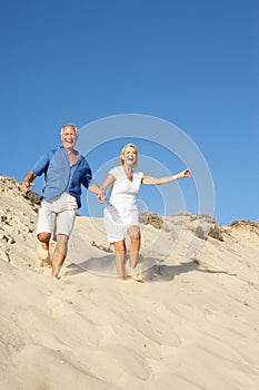 Senior Couple Enjoying Beach Holiday Running