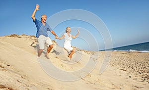 Senior Couple Enjoying Beach Holiday Running