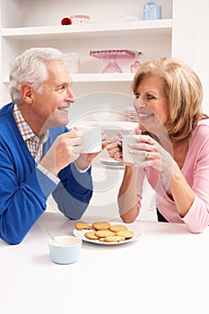 Senior Couple Enjoying Hot Drink In Kitchen