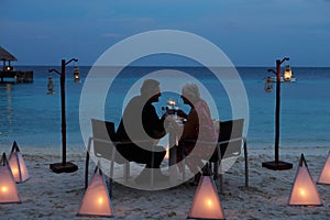 Senior Couple Enjoying Late Meal In Outdoor Restaurant