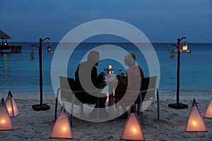 Senior Couple Enjoying Late Meal In Outdoor Restaurant