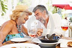 Senior Couple Enjoying Meal In Outdoor Restaurant