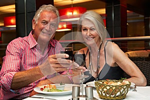 Senior Couple Enjoying Meal In Restaurant