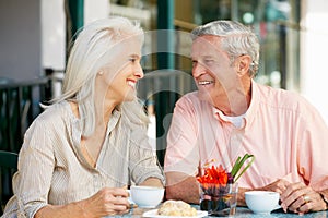 Senior Couple Enjoying Snack At Outdoor Cafe