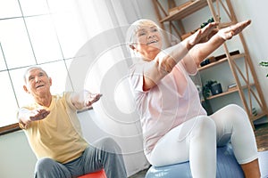 Senior couple exercise together at home doing aerobics hands in front