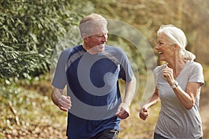 Senior Couple Exercising In Autumn Countryside During Covid 19 Lockdown