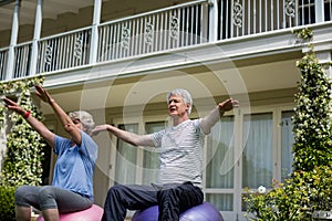 Senior couple exercising on fitness ball