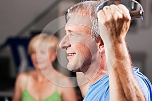 Senior couple exercising in gym